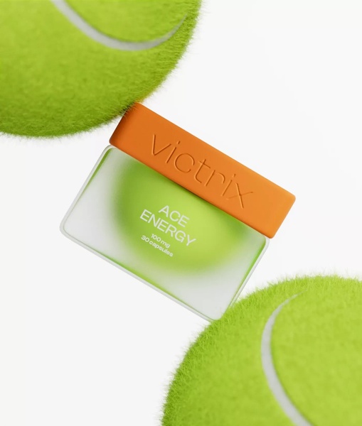 A clean, high-contrast creative featuring an energy supplement container suspended between two tennis balls, emphasizing performance.